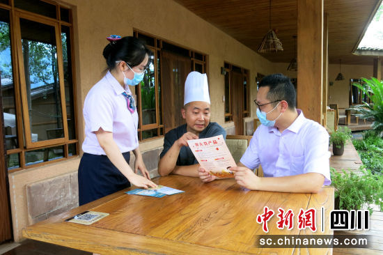 農(nóng)行工作人員為農(nóng)戶講解金融產(chǎn)品。四川農(nóng)行 供圖