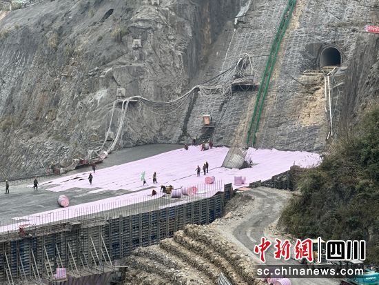 　　工人正給大壩穿上粉紅色“保溫被”。何浠攝