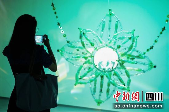 一位觀眾正在拍攝用垃圾“變身”而來(lái)的藝術(shù)作品。中國(guó)銀聯(lián) 供圖