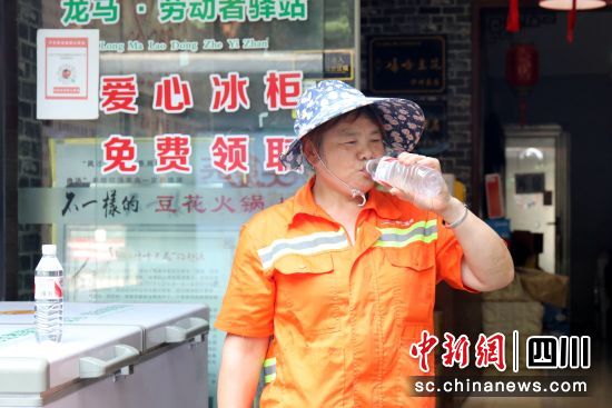 環(huán)衛(wèi)工在愛心冰柜前喝水。謝汶萍 攝