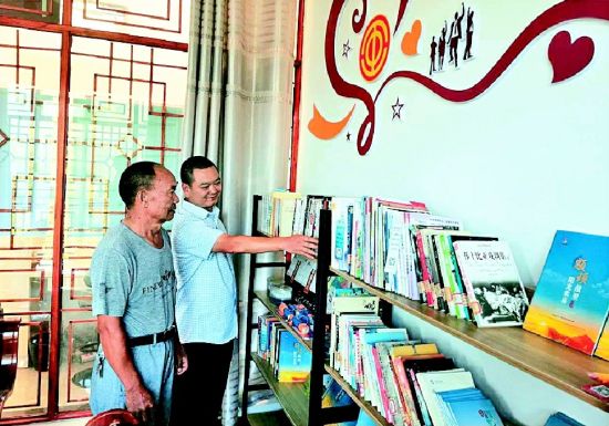 全國勞動模范楊華順(左)在景區(qū)工會驛站書屋了解藏書情況 全國勞動模范楊華順(左)在景區(qū)工會驛站書屋了解藏書情況